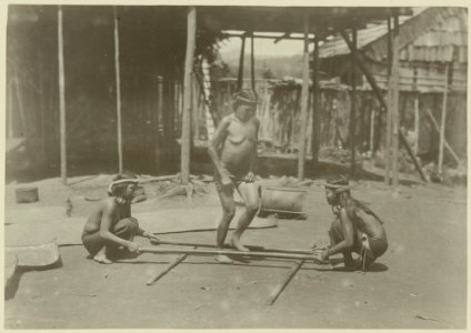 KITLV - 25689 - Demmeni, J. - Kayan woman dancing on a specific beat between rice pistils (kang kep). Upper Mahakam, Central Borneo - 1898-1900