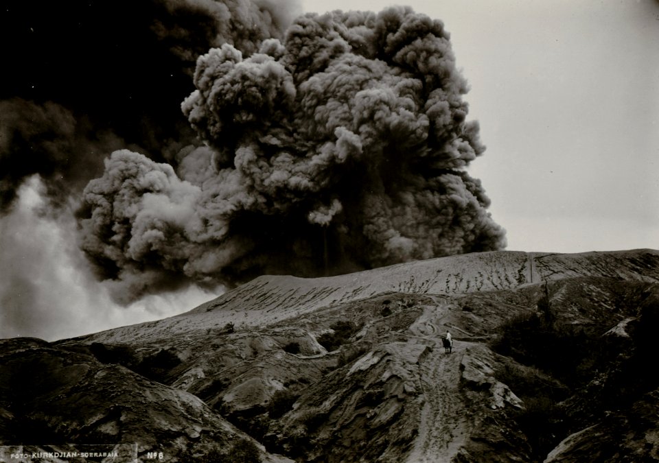 KITLV - 82399 - Kurkdjian - Soerabaja - Mount Bromo (Gunung Bromo) in the Tengger Mountains in East Java erupting with an ash plume. Man with horse - circa 1910