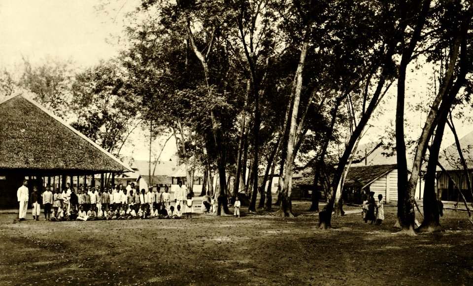KITLV - 78298 - Kleingrothe, C.J. - Medan - Teachers and schoolchildren of coolies of the Amsterdam Deli Company at Padang Bulan in Medan, Sumatra - circa 1900