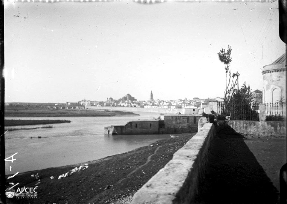 La ciutat de Còrdova amb el riu Guadalquivir i dos nens sobre un mur en primer terme