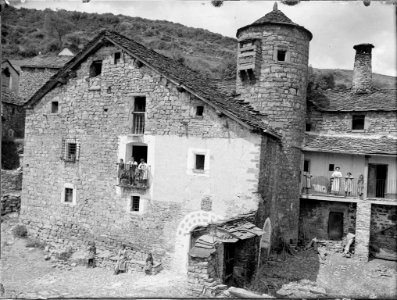 La casa de Carles Borsuel, casa Ruba, amb una torre circular i gent als balcons