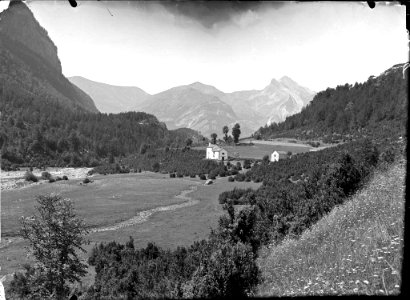 La vall d'Ordesa amb una casa i boscos i al fons el pic de Tendeñera
