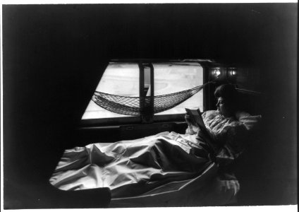 Lady reading in berth (with the) curtains up LCCN2012649450