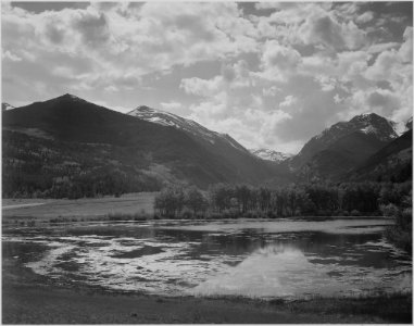 Lake and trees in foreground, mountains and clouds in background, In Rocky Mountain National Park,Colorado., 1933 - 19 - NARA - 519967