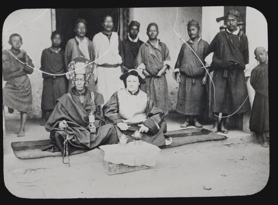 Lama with headdress and Caucasian man seated in front of nine boys and men, Tibet LCCN2012649866