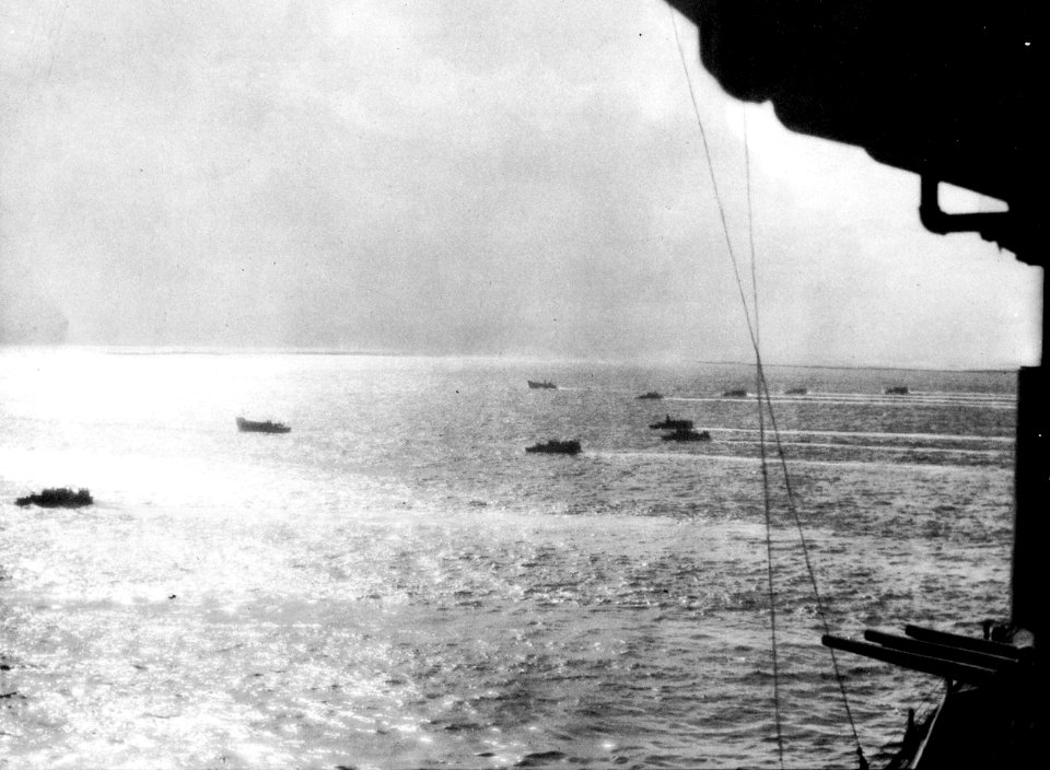 Landing craft passing USS Biloxi (CL-80) in 1945