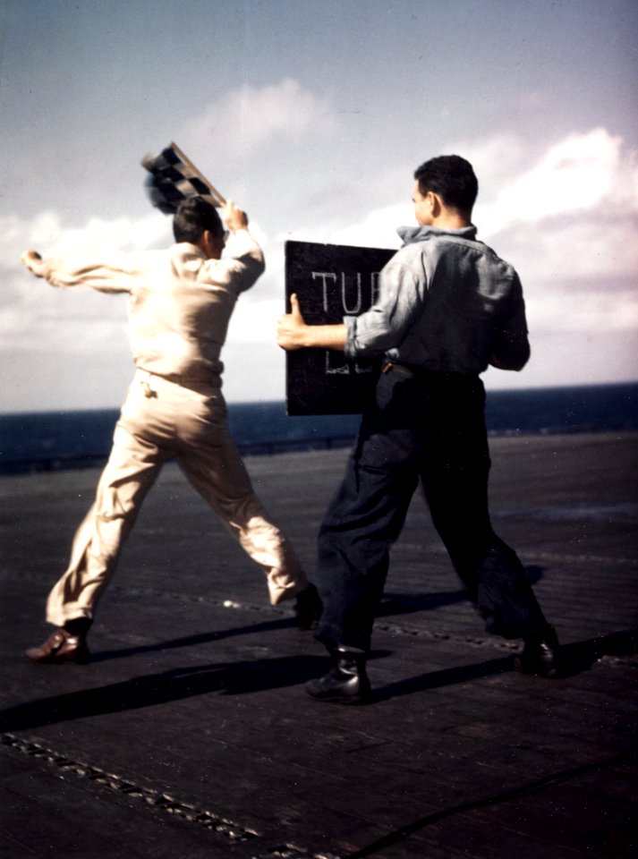 Landing Signal Officer launches aircraft aboard USS Lexington (CV-16), in early December 1943 (80-G-K-15294)