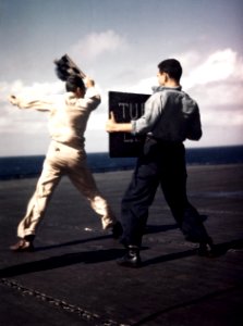 Landing Signal Officer launches aircraft aboard USS Lexington (CV-16), in early December 1943 (80-G-K-15294)