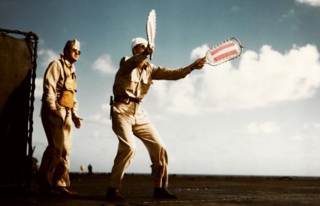 Landing Signal Officer aboard USS Lexington (CV-16) brings in a plane, circa in November 1943 (80-G-K-15293)