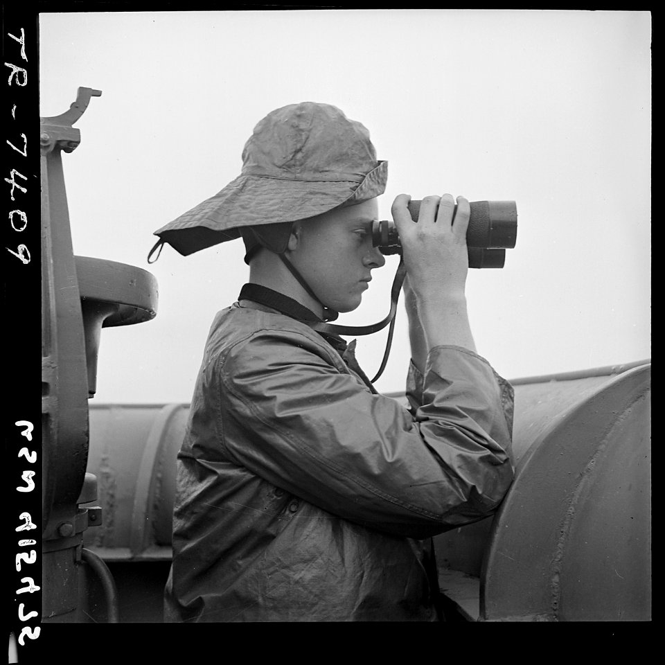 Lawrence Britton (SN2), on duty at port lookout aboard USS Nassau (CVE-16). - NARA - 520755