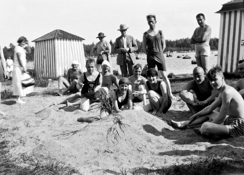 Lauttasaaren uimaranta Kasinon ranta. Keskellä vasemmalla olevalla miehellä kädessään kamera. (hkm.HKMS000005-000001ea)