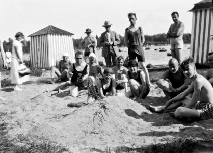 Lauttasaaren uimaranta Kasinon ranta. Keskellä vasemmalla olevalla miehellä kädessään kamera. (hkm.HKMS000005-000001ea)