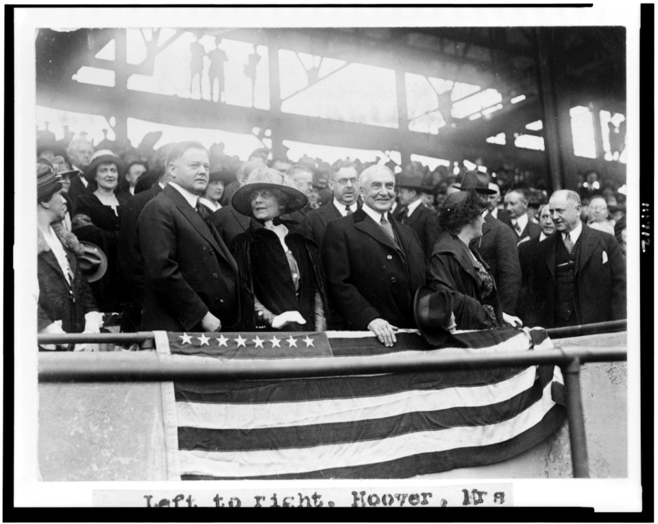 Left to right- Herbert Hoover, Mrs. Warren G. Harding, Warren G. Harding, Mrs. Herbert Hoover, and H.M. Daugherty, all standing, in grandstand, at baseball game LCCN94509129