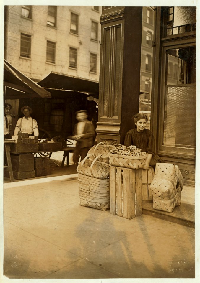 Lena Lochiavo, 11 years old, 209 W. Sixth St., Basket Seller, Sixth Street Market, Cincinnati. In front of saloon entrance. LOC nclc.03200