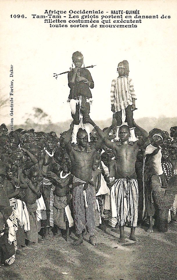 Les griots portent en dansant des fillettes costumées (Guinée)