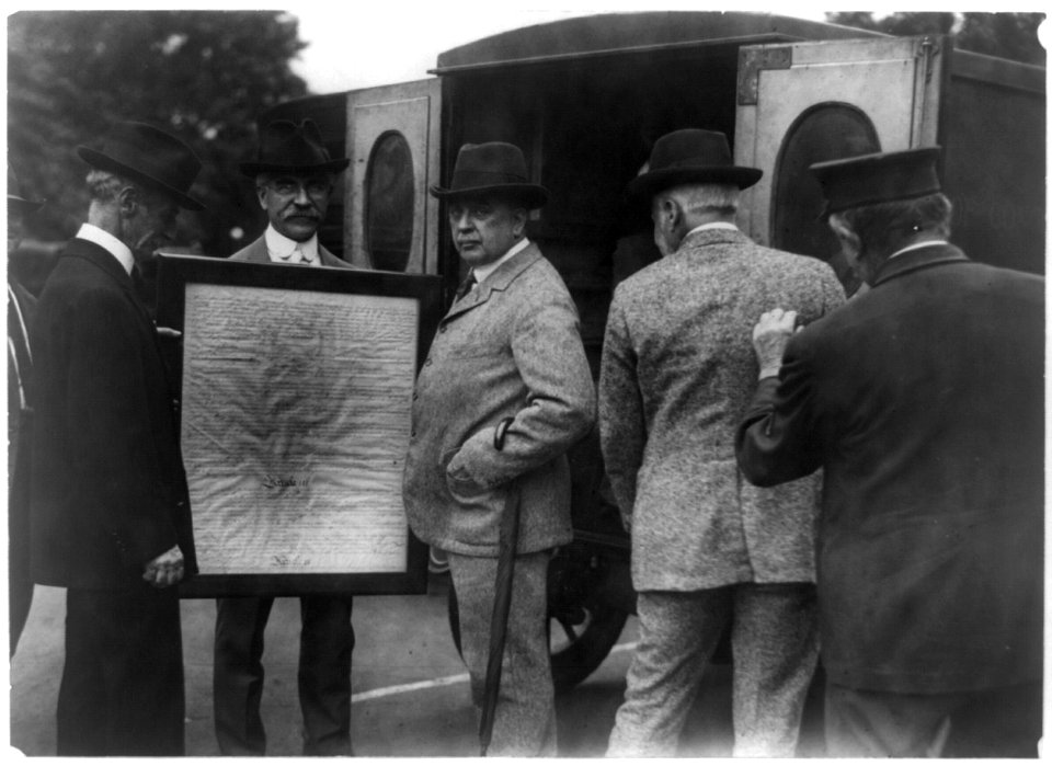Library of Congress officials transferring page 3 of the United States Constitution from the State Department to the Library of Congress in the Library's Model-T Ford mail wagon LCCN96507341
