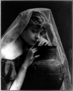 Lillian Gish, head-and-shoulders portrait, facing right, leaning on large pottery vase LCCN2005687253