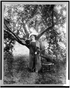Lillian Nordica, full-length portrait, standing under fruit tree, facing left LCCN95502470