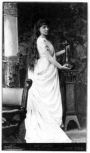 Lillie Langtry, 1853-1929, full-length portrait, standing, facing right, holding vase on stand LCCN2005683914