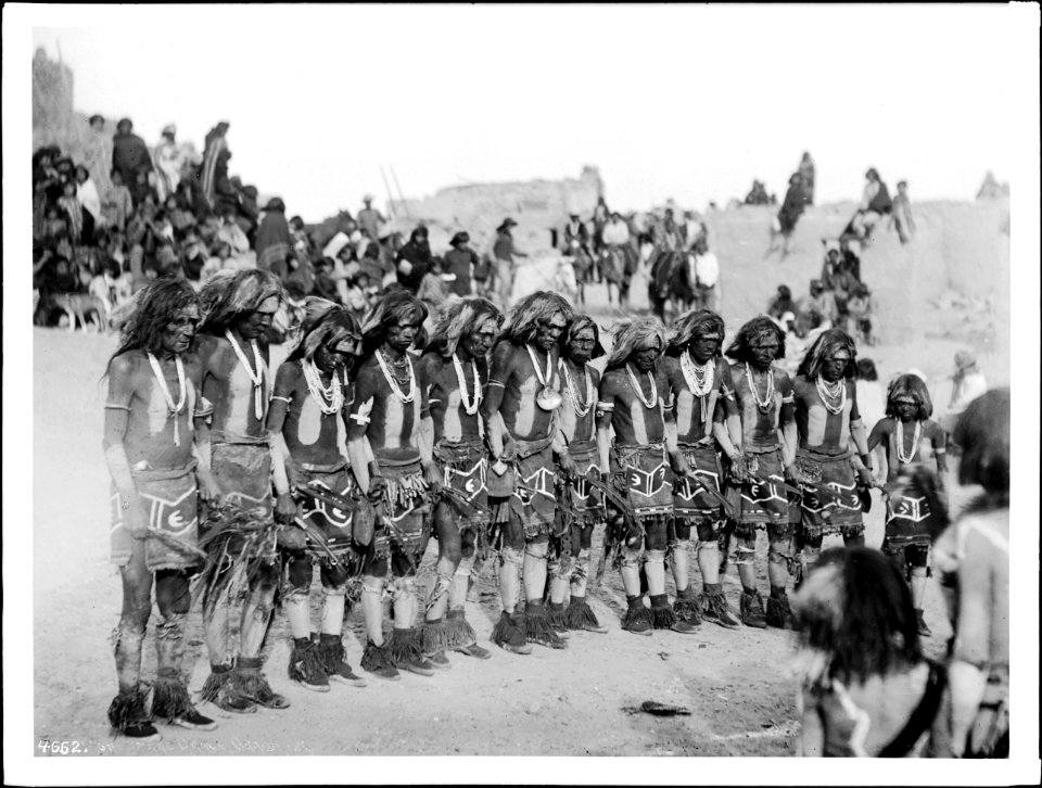 Line of a dozen Hopi snake priests singing songs and prayers before the kiva or kisi at the pueblo of Oraibi, Arizona, 1898 (CHS-4662)
