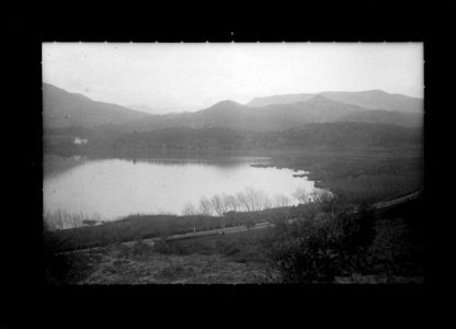 Llac al costat d'una carretera amb les muntanyes de fons (AFCEC VIDAL D 5013)