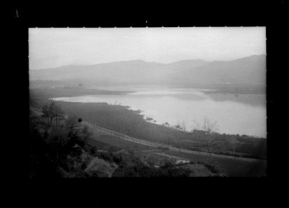 Llac al costat d'una carretera amb les muntanyes de fons