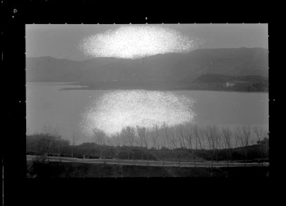 Llac al costat d'una carretera amb les muntanyes de fons (AFCEC VIDAL D 5017)