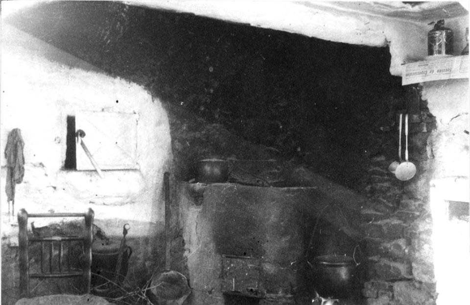 Llar amb olla al foc i estris diversos a la cuina de Cal Iglesies