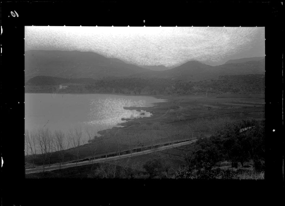 Llac al costat d'una carretera amb les muntanyes de fons (AFCEC VIDAL D 5018)