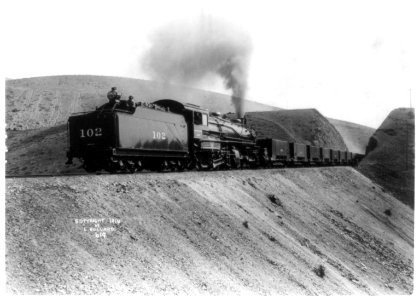 Locomotive no. 102 bringing railroad cars through gap, Utah LCCN2002723946 photo