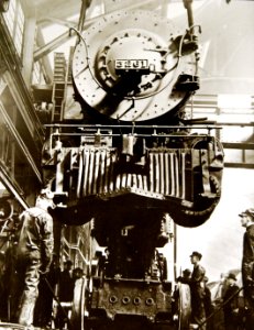 Locomotive 3261 is lowered onto wheels in repair shop (34624760471)
