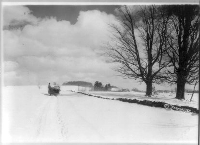 Looking down snow-covered road in New England; horse-drawn sled in background LCCN2005691602