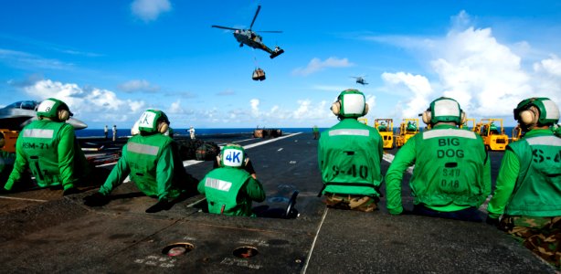 Logistics specialists stand by as an MH-60S Sea Hawk helicopter from Helicopter Sea Combat Squadron 8 delivers stores to the flight deck of the aircraft carrier USS John C. Stennis (CVN 74) during a vertical re 120908-N-OY799-472
