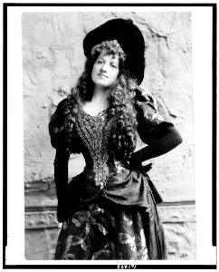 Lottie Collins, three-quarter length portrait, standing, facing left, left hand on hip LCCN90710354