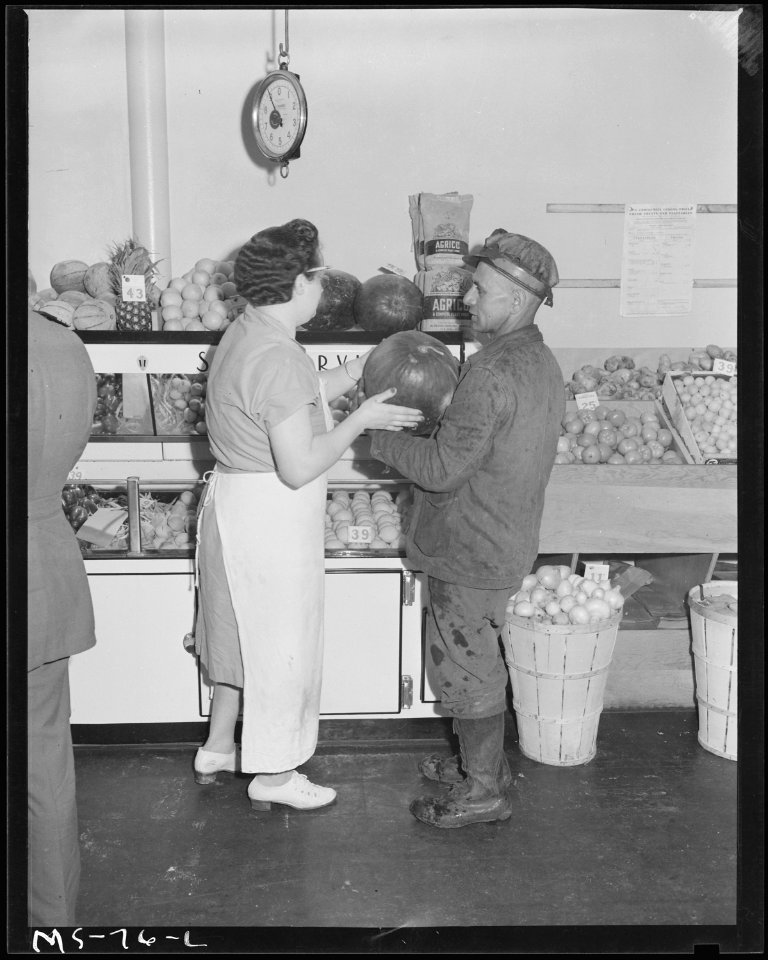 Louis Kobuchi, miner, buying watermelon from Mrs. Pearl Stevenson, clerk at company store. Pittsburgh Coal Company... - NARA - 540256