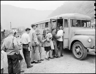 Louis Sergent, the tallest boy in a sport jacket, catches the bus which will take him into the Evarts High School... - NARA - 541375