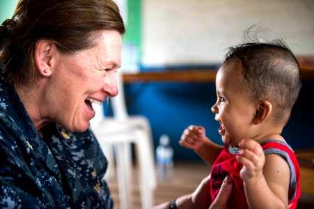 Lt. Cmdr. Carrie Dreyer laughs with a child during Continuing Promise 2015. (17977284260) photo