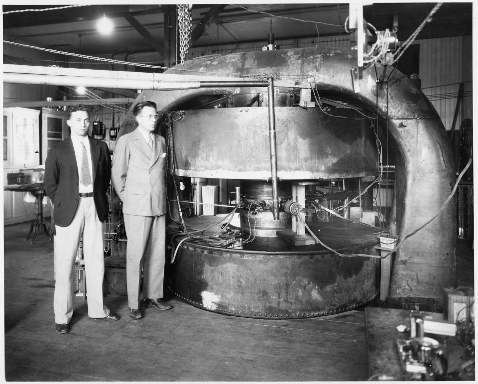 M. Stanley Livingston (L) and Ernest O. Lawrence in front of 27-inch cyclotron at the old Radiation Laboratory at the... - NARA - 558593