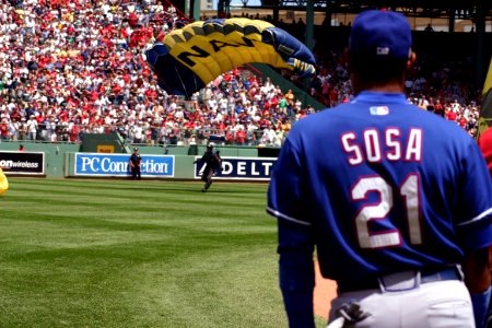 Major League Baseball's Sammy Sosa watches as a member of the Navy Parachute Team Leap Frogs lands in Boston's Fenway Park prior to a Red Sox Game photo
