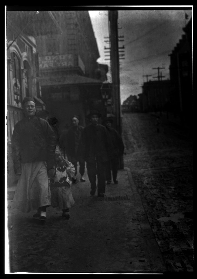 Man and a boy walking down a sidewalk with other people, Chinatown, San Francisco LOC agc.7a55039