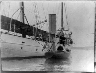 Man and woman in small boat alongside large boat or ship, Oyster Bay, Long Island, N.Y. LCCN89711956