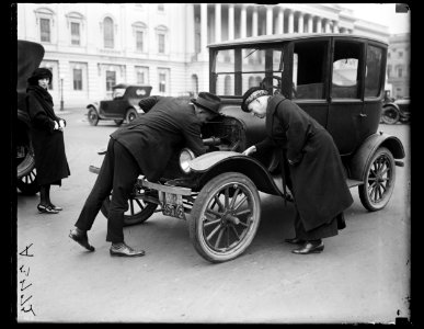 Man and woman examining automobile engine. U.S. Capitol, Washington, D.C. LCCN2016891011