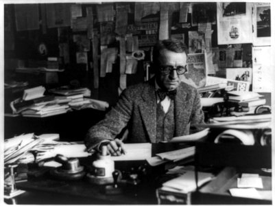 Man at desk reading typewritten pages LCCN89716102
