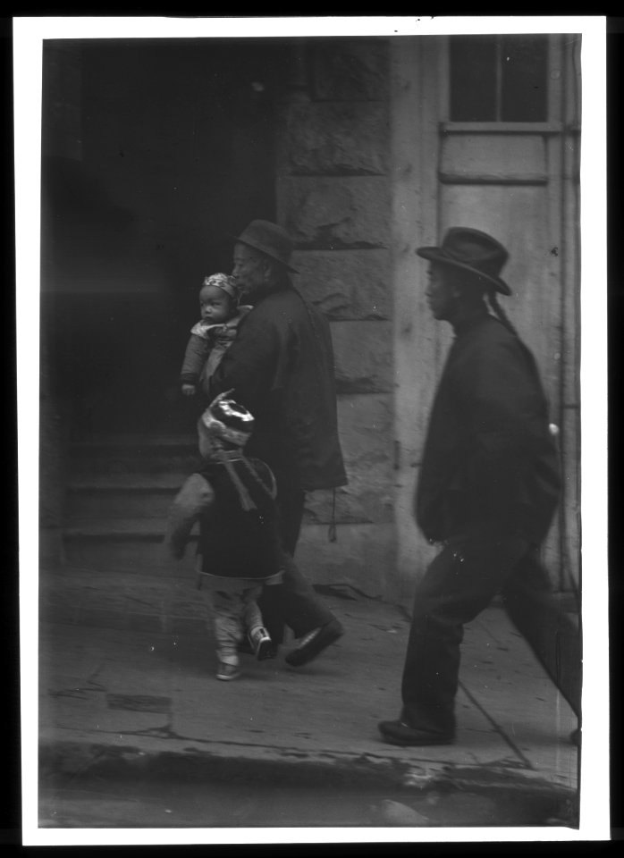 Man carrying a child walking with another child, Chinatown, San Francisco LOC agc.7a55096
