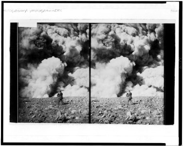 Man holding large camera photographing a cataclysmic event, possibly a volcano erupting LCCN96502547