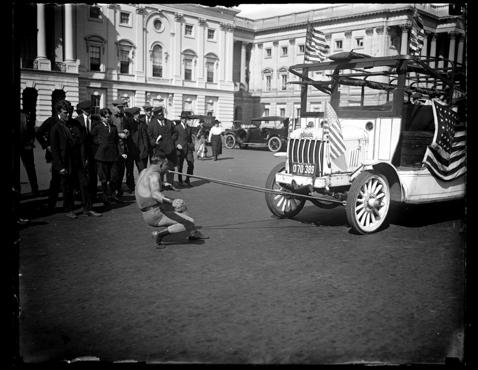 Man pulling bus with teeth outside U.S. Capitol, Washington, D.C. LCCN2016890777