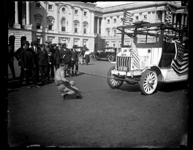 Man pulling bus with teeth outside U.S. Capitol, Washington, D.C. LCCN2016890777