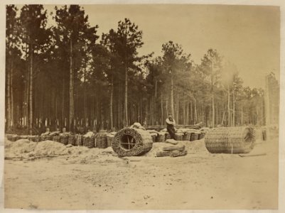 Man seated on gabions in engineer camp in front of Petersburg, Virginia LCCN2013649043