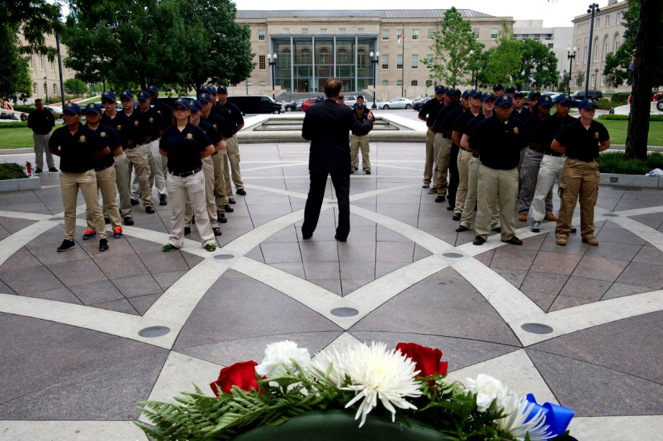 Man speaks to law enforcement explorers at National Law Enforcement Officers Memorial with wreath photo