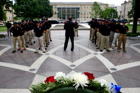 Man speaks to law enforcement explorers at National Law Enforcement Officers Memorial with wreath photo